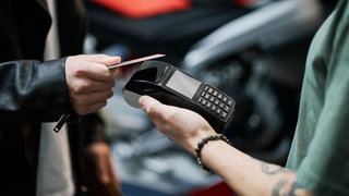 Person benutzt EC-Karte bei Kartenlesegerät (Symbolbild)