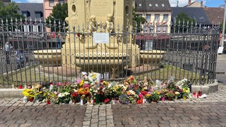 Gedenkort der Stadt Mannheim am Marktplatz mit Blumen und Kerzen