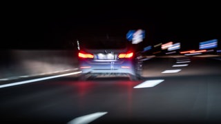 Ein Auto fährt bei Nacht auf einer Autobahn (Symbolbild).