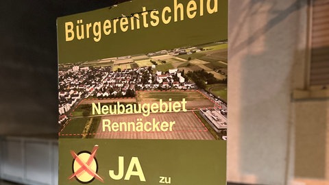 Plakat zum Bürgerentscheid mit einem "Ja" abgebildet am Straßenrand.