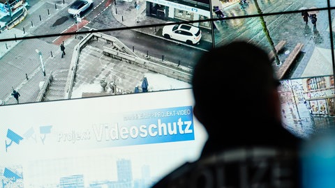 Polizist sitzt vor Bildschirmen des Videoschutzes in Mannheim
