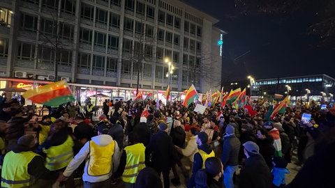Man sieht viele Menschen mit Flaggen demonstrieren 