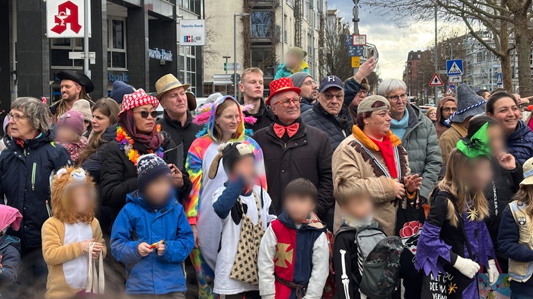 Verkleidete Besucher des Heidelberger Fastnachtsumzug stehen in mehreren Reihen.