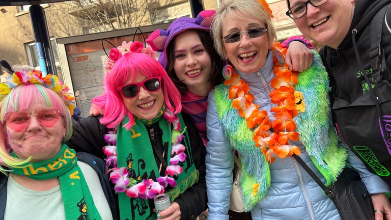 Mehrere Frauen mit bunten Blumenketten, Perücken und Sonnenbrillen in Heidelberg
