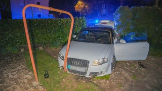 Ein Auto kommt in einem Vorgarten zum Stehen