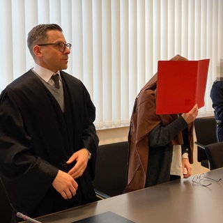 Vor Heidelberg steht eine 41-Jährige vor Gericht, die sich als Lehrerin ausgegeben haben soll. Vor Gericht verdeckt sie ihr Gesicht.