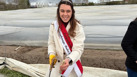 Die Lampertheimer Spargelkönigin Nadine III. hat den ersten Spargel aus dem Boden geholt.