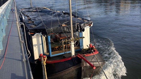 Lastenschiff angedockt an einen Frachter auf dem Rhein