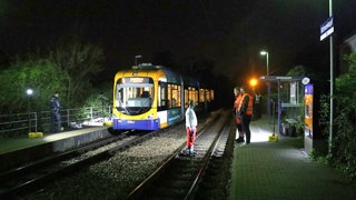 Eine Straßenbahn steht im Dunkeln am Gleis. Polizei und Rettungskräfte sind im Einsatz. Bei dem Unfall wurde eine Person schwer verletzt.