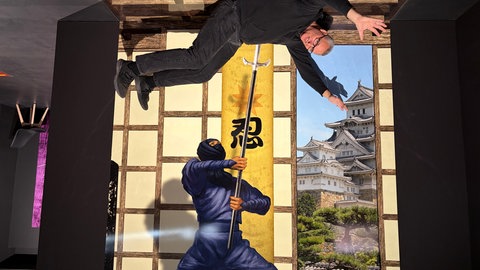 Durch das Drehen des Fotos auf den Kopf sieht es so aus, als würde der Samurai jemanden aufspießen, der sich aber in Wirklichkeit auf den Boden gelegt hat.