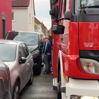 Feuerwehrleute prüfen, ob ihr Auto an einer engen Stelle durchkommt.