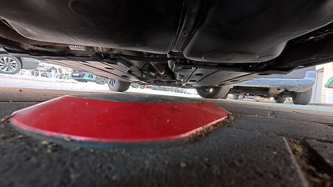 Ein roter Sensor unter einem Auto auf einem Parkplatz 