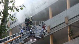Feuerwehr auf Drehleiter bei Brand in Mehrfamilienhaus