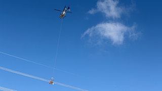 Arbeiten mit Helikopter: Vogelschutzkugeln werden an einer Stromeitung bei Weinheim angebracht