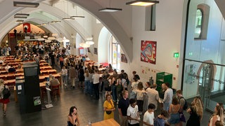 Studierende, die im Marstall für ihr Mittagessen anstehen.