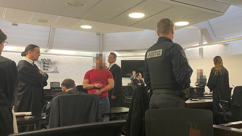 Mehrere Angeklagte stehen im Saal des Stuttgarter Landgerichts und warten auf die Urteilsverkündung.