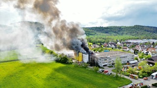 Dichter Rauch steigt von einer Lagerhalle in Schorndorf-Miedelsbach auf. 