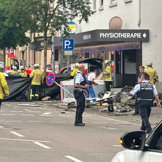 Trümmer liegen nach einem Unfall auf einer Kreuzung. Rettungskräfte sperren die Unfallstelle ab.