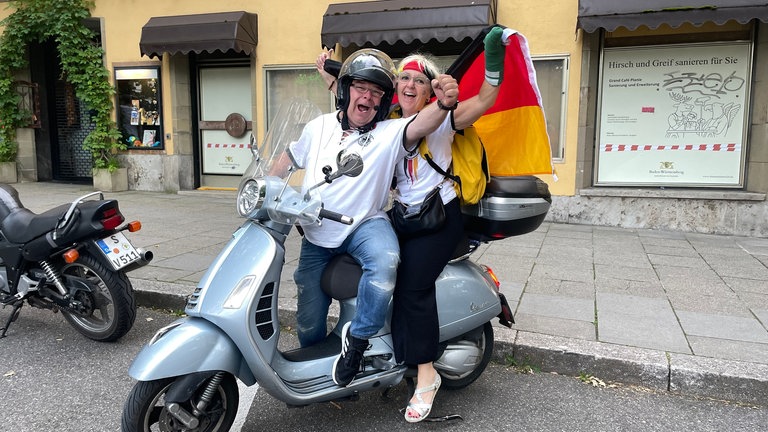 Manuela und Michel haben die Vespa bestiegen und fahren nun los im Korso durch Stuttgart.