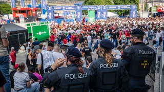 Einsatzkräfte der Polizei beobachten die Lage an der Fan Zone am Schlossplatz.
