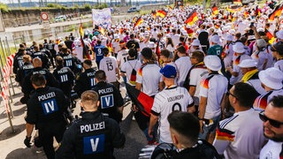 Fußballfans werden beim Fanmarsch in Stuttgart von der Polizei begleitet