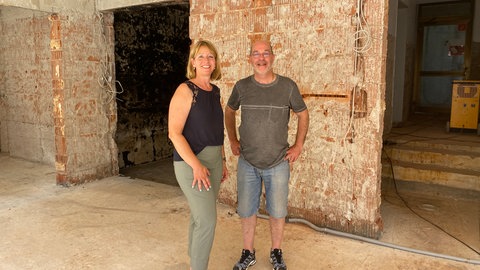 Das Ehepaar Hinderer steht in ihrer zerstörten Metzgerei in Rudersberg. Nach der Überschwemmung muss kernsaniert werden.