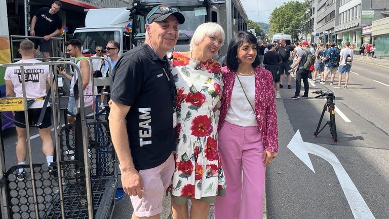 Die beiden Grünen-Politikerinnen Muhterem Aras und Claudia Roth stehen vor dem Start der CSD-Parade durch Stuttgart zusammen mit Organisator Detlef Raasch (von rechts).