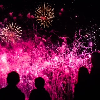 Besucherinnen und Besucher der "Flammenden Sterne" sehen sich im Scharnhauser Park in Ostfildern ein Musikfeuerwerk an.