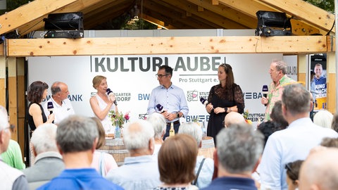 Auf dem Weindorf in Stuttgart steht Cem Özdemir auf der Bühne und hat ein Mikrofon in der Hand. 
