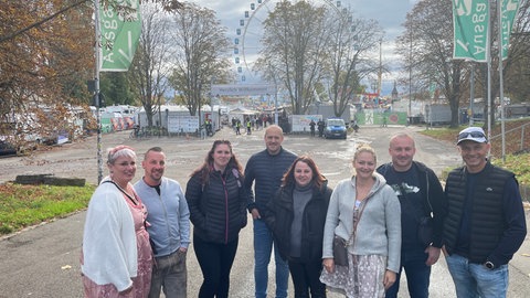 Cindy Gesell und ihre Gruppe aus Hagenau im Elsass stehen in Stuttgart vor dem Eingang des Cannstatter Wasen.