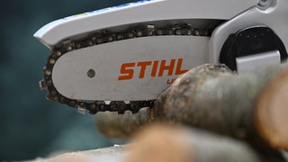 Das Logo des Motorsägen- und Gartengeräteherstellers Stihl ist an einer kleinen akkubterieben Säge angebracht, die Holz zersägt. Sägenhersteller Stihl aus Waiblingen hat der Politik mit Abwanderung gedroht, wenn Deutschland als Wirtschaftsstandort nicht wieder attraktiver gemacht wird.