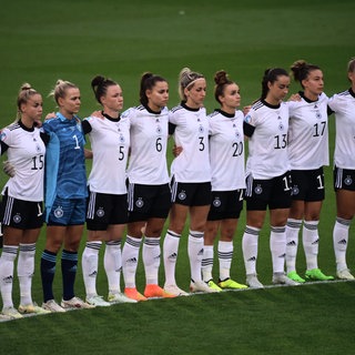 Die deutsche Fußball-Nationalmannschaft der Frauen steht in einer Reihe an der Mittellinie und wartet. 