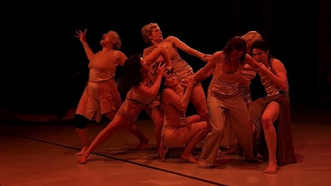 Sieben Frauen in rötlichem Licht