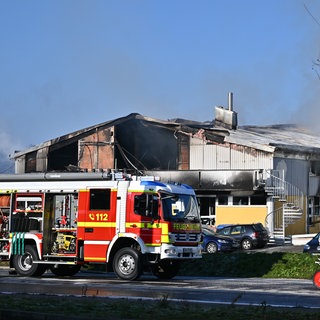 Ein Feuerwehrfahrzeug steht vor dem abgebrannten Gebäude in Schorndorf 