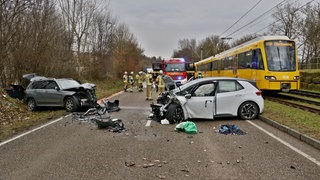 Nach einem Unfall stehen die beiden beschädigten Autos auf der Straße.