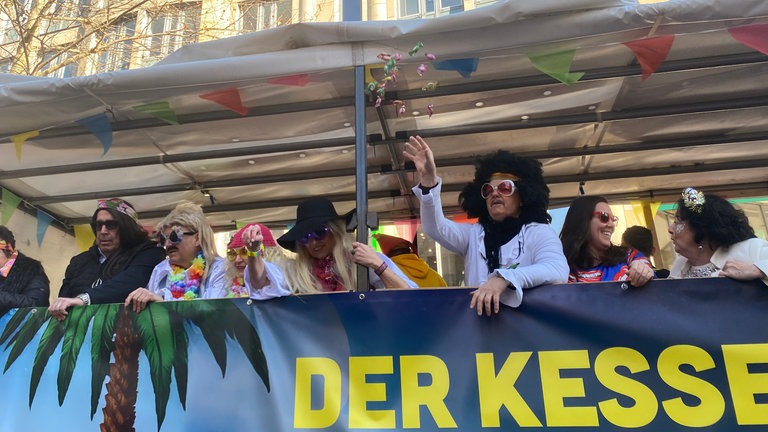 Drei Dinge brauchte jeder Mitfahrende auf einem Umzugswagen bei der Straßen-Fasnet in Stuttgart: Perücke, Sonnenbrille, Kamelle und Spaß. Ups, das waren ja vier Dinge ...