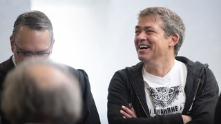 Michael Ballweg (r), Gründer der "Querdenken"-Bewegung, steht mit seinen Anwälten in einem Saal des Landgerichts Stuttgart. 