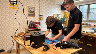 Schüler bauen in einer Werkstatt an einer Powerbank