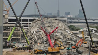 In Bangkok war ein im Rohbau befindliches Hochhaus bei dem Erdbeben von Myanmar und Thailand eingestürzt. Nun laufen dort die Suche nach Opfern und die Aufräumarbeiten. 