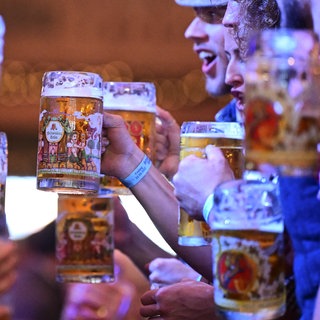 Anstoßen mit Bier auf dem Stuttgarter Frühlingsfest 2024