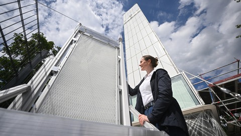 Die Architektin Christina Eisenbarth präsentiert ihre HydroSKIN--Technologie. Im Hintergrund ist das Testgebäude der Universität Stuttgart zu sehen.