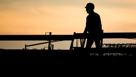 Die Silhouette eines Bauarbeiters zeichnet sich auf einer Baustelle vor dem verfärbten Morgenhimmel ab (Symbolbild). In holzgerlingen können junge Menschen bei einem Freiwilligen Handwerksjahr in verschiedene Handwerksberufe reinschnuppern. Das soll Orientierung bieten und führt vielleicht sogar zum Traumjob.