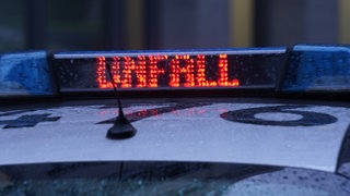 Der Schriftzug "Unfall" ist neben dem Blaulicht auf dem Dach eines Polizeiautos zu lesen.