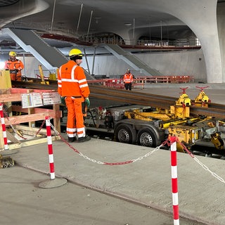 In der Tiefbahnhofshalle in Stuttgart werden die ersten Gleise verlegt. Ab dem Sommer können darauf Züge im Testbetrieb fahren.