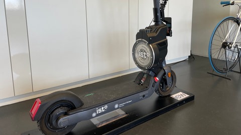 Autonomer E-Scooter im Labor der Universität Stuttgart auf einer Ladestation