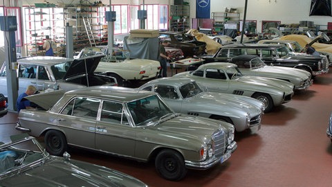 Oldtimer-Werkstatt mit Mercedes-Modellen, die restauriert werden.