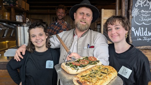 Oliver Fleiß (Mitte) präsentiert eine seiner Pizzen.