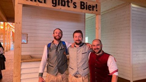 Drei Männer in einem Festzelt auf dem Frühlingsfest in Stuttgart.