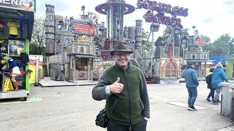 ein Mann vor einem Fahrgeschäft auf dem Stuttgarter Frühlingsfest