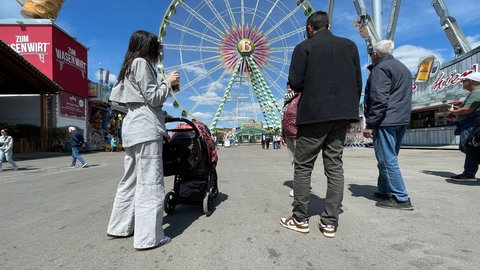 Besucher mit Kinderwagen auf dem Frühlingsfest 2025 in Stuttgart bei bestem Wetter.